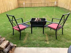 dos sillas y un perro en una cama de flores en un patio en Furnished 3-bed- Townhome in the Hills Near Fort Cavazos, en Copperas Cove