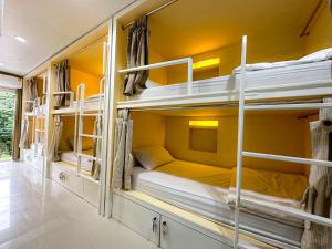 a room with three bunk beds in a house at HUG Backpackers in Chiang Mai