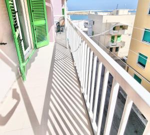 a balcony with green doors and a view of the ocean at Colasante House in Molfetta
