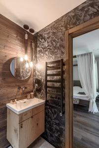 a bathroom with a sink and a mirror and a bed at Ranča in Molėtai