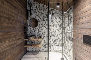 a bathroom with a shower with a black and white wallpaper at Ranča in Molėtai