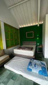 Duas camas num quarto com uma parede verde em Nyawang Merapi em Cangkringan