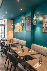 una fila de mesas en un restaurante con paredes azules en Hotel-Restaurant Le Victoria, en Rennes