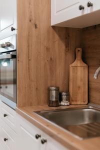 uma cozinha com um lavatório e uma tábua de cortar madeira em Bell Tower Apartment em Mostar