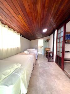 a room with two beds and a wooden ceiling at Pousada Tropicália in Arraial d'Ajuda