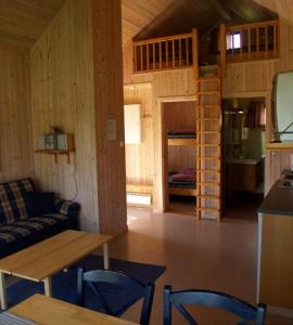una sala de estar con sofá y mesa en una cabaña en Risør Gjestehus, en Risør