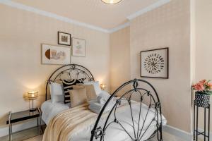 a bedroom with a bed and two lamps and pictures at Guest Homes - Gorleston Sands Retreat in Gorleston-on-Sea