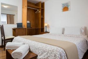 ein Hotelzimmer mit einem großen Bett und einem Stuhl in der Unterkunft Hotel Premier Bariloche in San Carlos de Bariloche