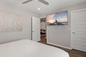 a bedroom with a white bed and a painting on the wall at The Sanctuary - Work Friendly & Near Downtown in Indianapolis