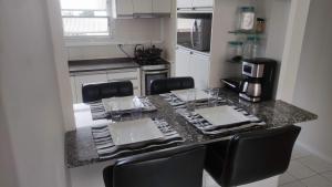 a kitchen with a table with chairs and a counter top at Apartamento calmo e aconchegante in Florianópolis