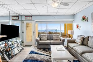 un soggiorno con divani e TV a schermo piatto di Continental Condo 118 a Panama City Beach