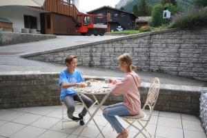 a boy and a girl sitting at a table at Sonnenwirbel in Saas-Fee
