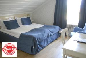 Un dormitorio con una cama con sábanas azules y una mesa. en Tällbergsgårdens Hotell en Tällberg