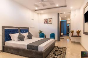 een slaapkamer met een bed en twee blauwe stoelen bij The Hillside inn by Exotic Stays in Kasauli