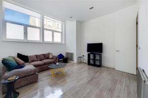 a living room with a couch and a tv at Luxurious 4 Bedroom Entire Flat in King's Cross in London