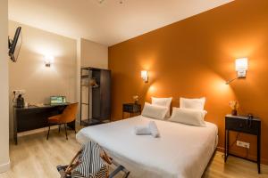 um quarto de hotel com uma cama grande e uma secretária em Hotel-Restaurant Le Victoria em Rennes