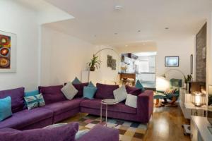 een woonkamer met een paarse bank en blauwe kussens bij Milton Mews - Spacious and modern 3 bedroom apartment in Portsmouth in Portsmouth