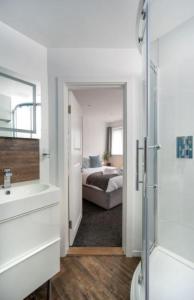 a bathroom with a bed and a sink and a mirror at Milton Mews - Spacious and modern 3 bedroom apartment in Portsmouth in Portsmouth