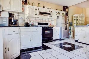 a kitchen with white cabinets and black and white tile floors at Casa Palma in La Paz