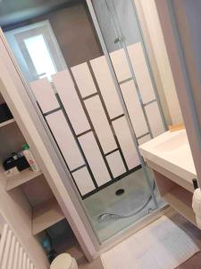 uma casa de banho com um chuveiro e uma porta de vidro em Chalet de 3 chambres avec piscine partagee jacuzzi et jardin amenage a Hasparren em Hasparren