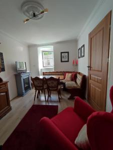 sala de estar con sofá rojo y mesa en Apartament 44, en Lądek-Zdrój