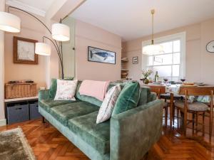 a living room with a green couch and a table at Astondene in Southwold