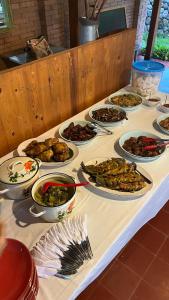 uma mesa com muitos pratos de comida em Nyawang Merapi em Cangkringan