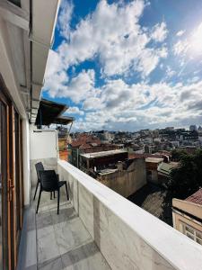 una silla sentada en un balcón con vistas a la ciudad en TAKSİM HAVANA HOTEL SUİTES en Estambul