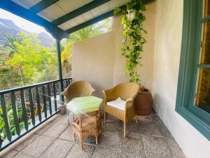 a patio with two chairs and a table on a balcony at Finca Origen · Casa Trinidad · Rural· Unique in San Pedro