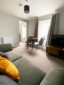 a living room with a couch and a flat screen tv at Poldice Valley Apartments in Chacewater