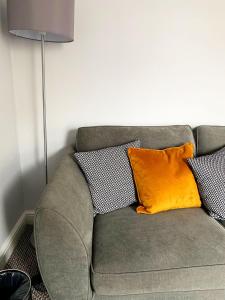 a couch with three pillows on it next to a lamp at Poldice Valley Apartments in Chacewater