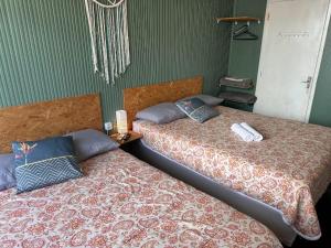 dos camas sentadas una al lado de la otra en una habitación en Quarto 6 no Centro de Itajaí, Ar+SmartTv, en Itajaí