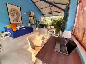 Kiki Peaceful Studios Mandrem في ماندريم: غرفة معيشة مع طاولة مع لاب توب عليها