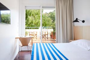 ル・ラヴァンドゥーにあるオテル カリフォルニアのベッド付きのホテルルームで、パティオの景色を望めます。