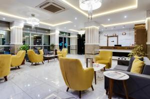 un vestíbulo de un hotel con mesas y sillas amarillas en PARK YALÇIN HOTEL, en Mersin