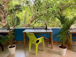 stół i zielone krzesło na patio z drzewami w obiekcie Kiki Peaceful Studios Mandrem w mieście Mandrem