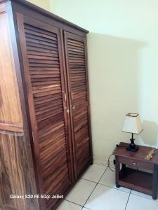 eine Holztür in einem Zimmer mit einem Tisch und einer Lampe in der Unterkunft LA MARINA 3 in Ambodifototra