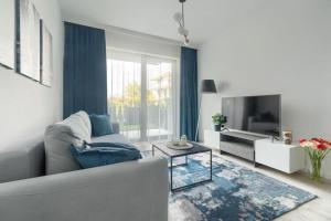 a living room with a couch and a tv at Ground floor apartment with a garden, close to the beach, Niechorze in Niechorze