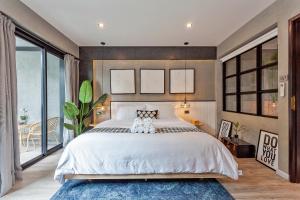 a bedroom with a large bed with two stuffed animals on it at Chic loft in Bangkok