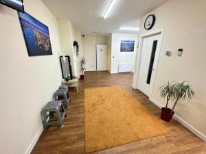 una oficina con un pasillo con sillas y una alfombra en IBROX GuestHouse en Glasgow