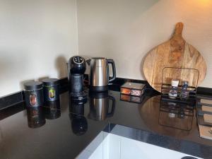 una encimera con tazas de café y una cuchara de madera en Vakantiehuisje de Wender en Ambt Delden