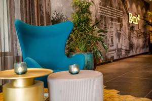 a blue chair and a table in a room at Motel One Ulm in Ulm