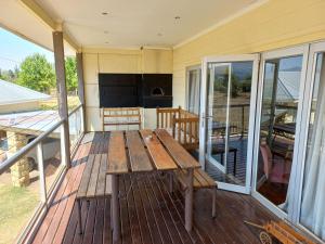 a porch with a wooden table on a deck at Twogether House in Clarens