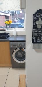 a washing machine in a kitchen next to a window at The Grove - 3 Bed updated detached house- sleeps upto 8 guests- West Midlands in Fallings Park