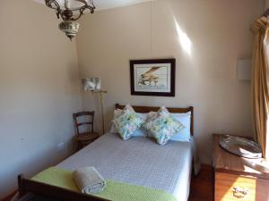 a small bedroom with a bed and a chandelier at Twogether House in Clarens