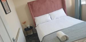 1 dormitorio con 1 cama grande y cabecero rojo en The Grove - 3 Bed updated detached house- sleeps upto 8 guests- West Midlands en Fallings Park