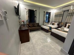un soggiorno con 2 letti e un divano di Villa Mahasok hotel a Luang Prabang