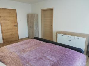 1 dormitorio con edredón morado en la cama en Happy Apartment, en Grafenwöhr