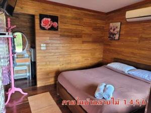 ein kleines Bett in einem Zimmer mit Holzwänden in der Unterkunft The Memorize Resort in Ban Non Na Yao