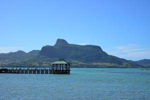 a pier with a gazebo in the middle of the water at Mahebourg Family Home in Mahébourg